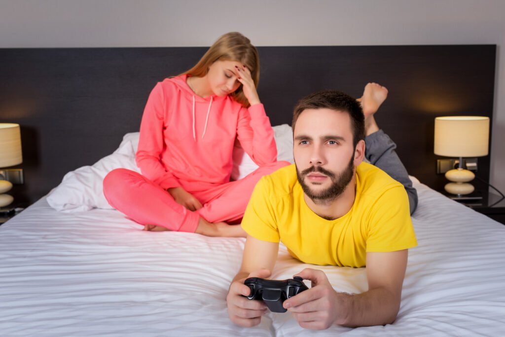 Young couple having playing videogames in bed
